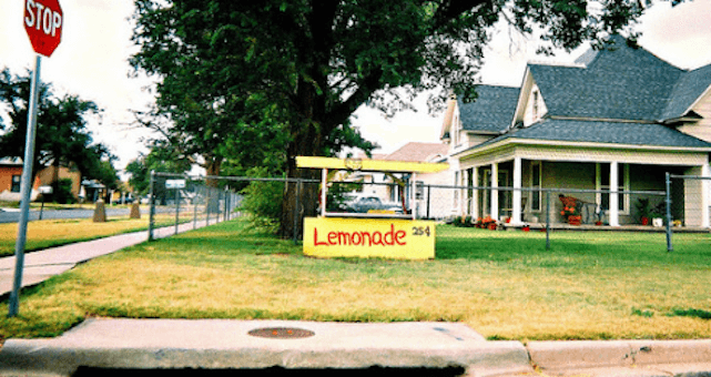 Invest in community | A photograph of a house with a lemonade stand