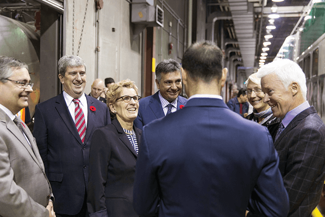 Ontario Premier Kathleen Wynne, with Transportation Minister Glen Murray (left, wearing poppy) and Finance Minister Charles Sousa (right), announce provincial green bonds program on Oct. 30.