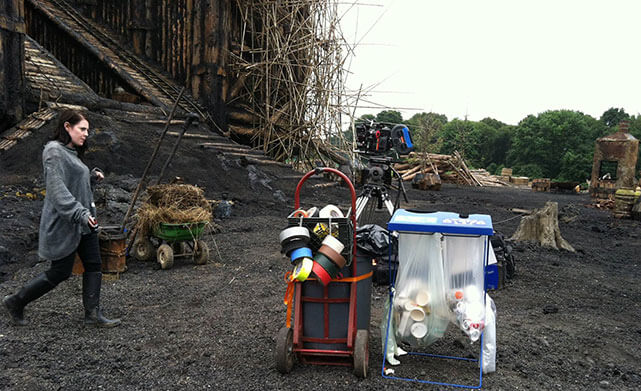 An Earth Angel crew member collects recyclables on the set of Noah.