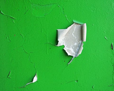 ESG communications need a makeover | An image of a green wall with chips in the paint